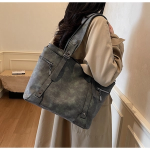 Detail view of retro gray-green tote bag with textured matte leather and silver zippers