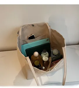 Top view of beige canvas tote bag interior showing capacity for tablets and essentials