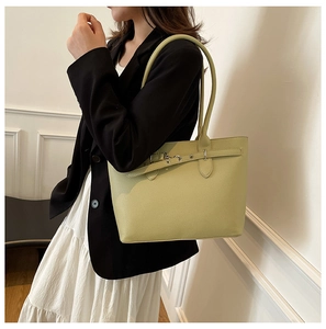 Détail du cabas en cuir grainé vert clair avec boucle décorative et bandoulière
