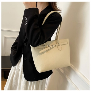 Vue détaillée du cabas beige en cuir grainé avec ceinture décorative et boucle en métal