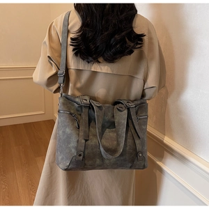 Detail view of large retro dark grey tote bag with textured leather and metal rivets