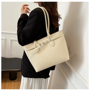 Détail du sac cabas crème en cuir grainé avec rivets argentés et bandoulière