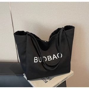 Close-up of the white BUDBAO embroidery on the black canvas tote bag for daily use