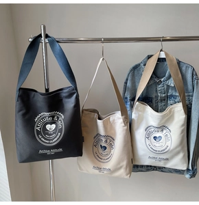 Vue détaillée des sacs seaux en toile avec logo vintage en noir, beige et blanc cassé