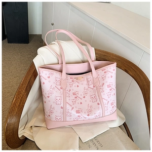 Detail der rosa Tragetasche mit Cartoon Katzen und Kaninchen Prints und goldenem Metallemblem