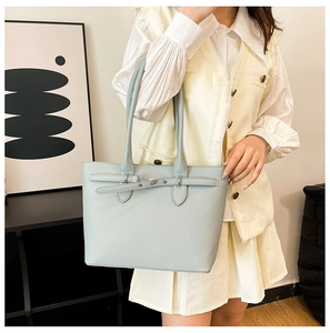 Sac fourre-tout bleu clair en cuir grainé lychee dans un décor minimaliste