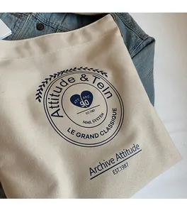 Gros plan d'un sac fourre-tout en toile crème avec emblème bleu et texture douce