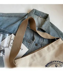Détail d'un sac cabas en toile beige avec bandoulière large et imprimé graphique