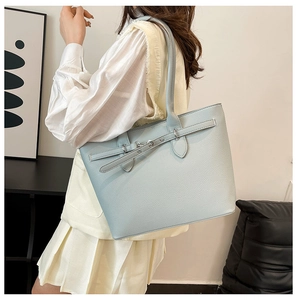 Détail du sac cabas en cuir bleu clair à motif litchi avec boucle et bandoulière élégante