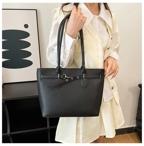Gros plan du sac cabas noir à texture litchi avec boucle métallique argentée élégante