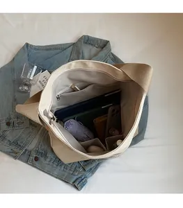 Vue détaillée de la grande capacité intérieure du sac en toile beige avec poches de rangement