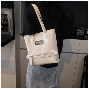 Off-white large tote bag with front zipper pocket shown worn on a model's shoulder