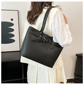 Détail d'un sac cabas en cuir grainé noir avec des garnitures métalliques argentées