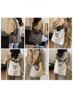 Collage de grands sacs fourre-tout en toile marron, beige et blanc portés par un mannequin