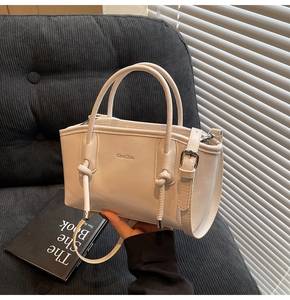 Dettaglio della borsa tote in pelle opaca bianco crema con manico e inserti in argento