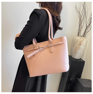 Détail du sac cabas rose en similicuir texturé porté à l'épaule par un mannequin