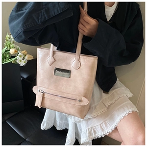 Detail of pink pleated PU leather tote bag with metallic logo and zipper pocket detail