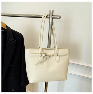 Détail du sac cabas en cuir crème texturé avec une boucle argentée élégante