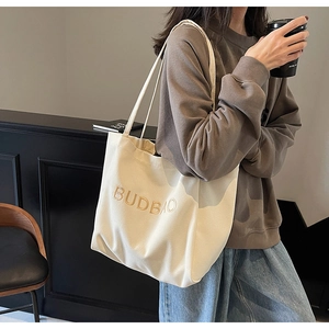 Cream canvas tote bag with BUDBAO embroidery shown in a daily lifestyle setting