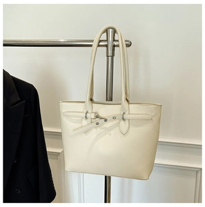 Détail du sac cabas en cuir crème avec boucle argentée et fines lanières d'épaule