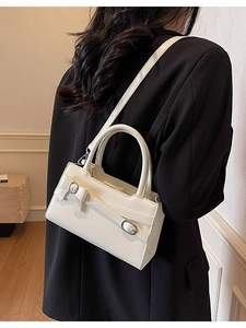 Elegant cream bow mini crossbody bag for women worn by model at 45 degree angle