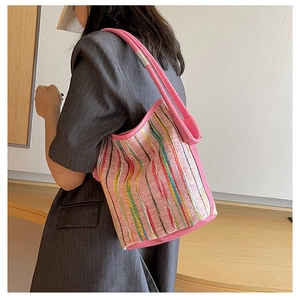 Detail of colorful striped fabric and pink leather trim on the bucket bag