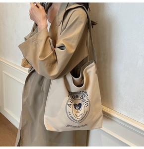Détail d'un grand sac cabas en toile beige avec un sceau académique vintage bleu imprimé