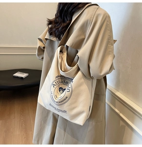 Détail du sac cabas en toile blanc cassé avec imprimé bleu vintage et texture robuste