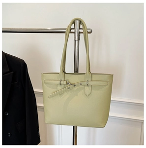 Détail d'un sac cabas vert clair avec texture grainée et sangle à œillets métalliques