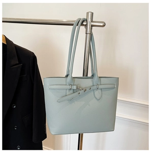 Détail d'un sac cabas bleu clair avec texture cuir grainé et boucle argentée