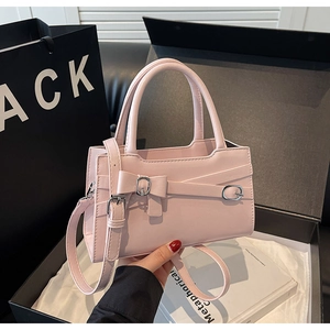 Pink fashion handbag with bow and metal buckle detail inside a premium gift box