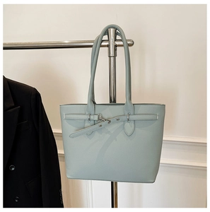 Détail d'un sac cabas vert menthe en cuir grainé avec crochets argentés et longues anses