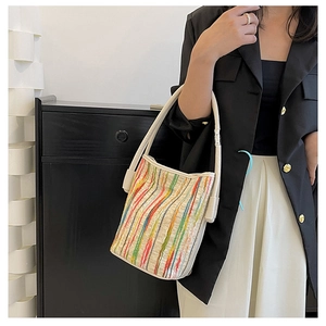 Detailed close-up of a vibrant vertical striped colorful tote bag with cream shoulder straps