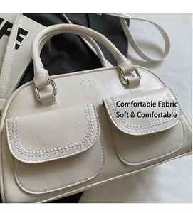 Dettaglio della borsa Boston bianco crema con cuciture intrecciate e due tasche