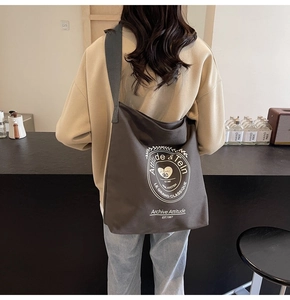 Détail de la vue arrière d'un sac cabas en toile marron foncé avec logo blanc imprimé