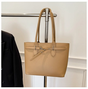 Détail du sac cabas camel montrant la texture cuir grainé et la boucle décorative