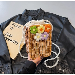 Détails du sac seau en paille avec fleurs au crochet et bandoulière en perles nacrées