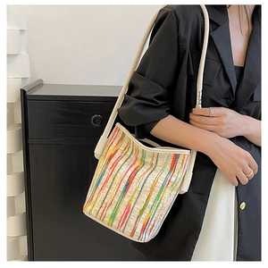 Detail einer bunten gestreiften Canvas-Beuteltasche mit Textur und cremefarbenem Gurt