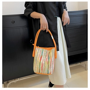 Detail showing colorful vertical stripes on a textured beige pleated tote handbag
