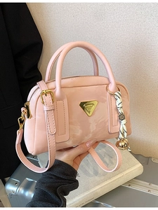 Sac bowling en similicuir rose avec logo doré et foulard décoratif tenu à la main