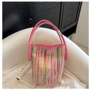 Close-up of pink woven stripe bucket bag with leather handle on white chair