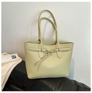 Gros plan d'un sac cabas vert clair montrant le cuir grainé et la boucle en métal