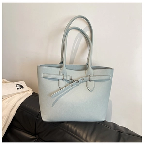 Détail du sac cabas en cuir grainé bleu clair avec finitions métalliques et anses larges