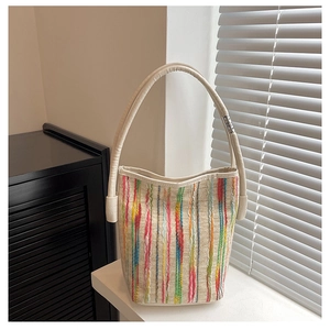 Detailed texture of colorful woven stripes on a stylish mini bucket bag with leather trim