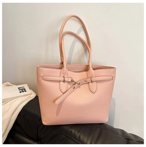 Détail d'un cabas rose en cuir grainé avec boucle métallique et longues anses fines