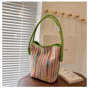 Detailed close-up of a colorful knitted bucket bag with vibrant green leather handles