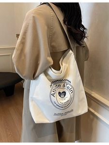 Sac cabas en toile blanche avec imprimé vintage bleu marine porté par un mannequin
