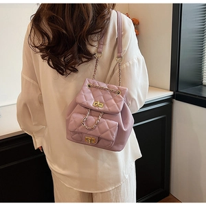 Close-up of lavender quilted leather backpack with gold chain straps and twist lock