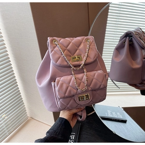 Close-up of purple quilted backpack with gold twist lock and metallic chain detail