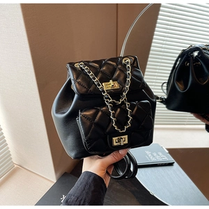 Detail of black quilted leather mini backpack with gold chain and twist-lock clasp
